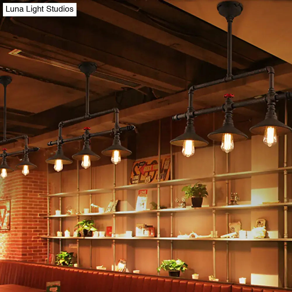 Industrial bronze pipe island light featuring black pipe pendant lights with exposed filament bulbs for dining room use