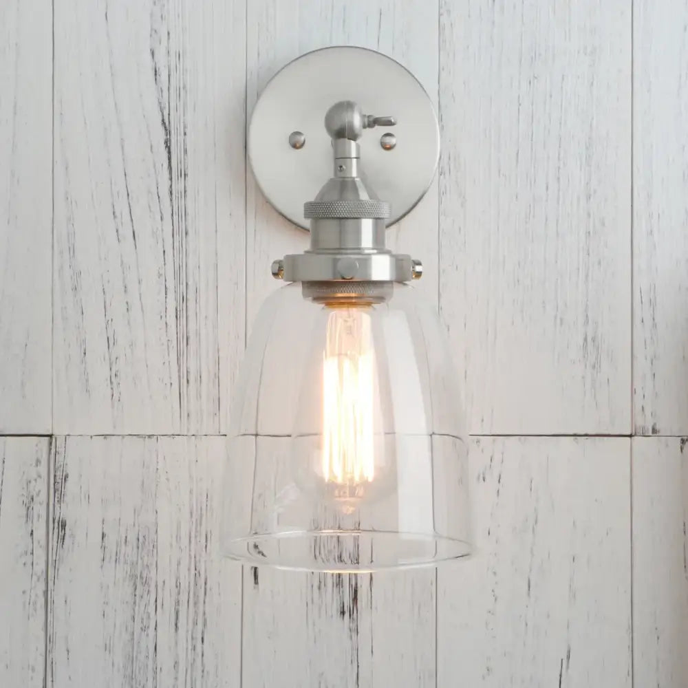 A sleek industrial brushed nickel wall lamp with clear glass dome and exposed edison bulb for bedroom decorbites clear glass