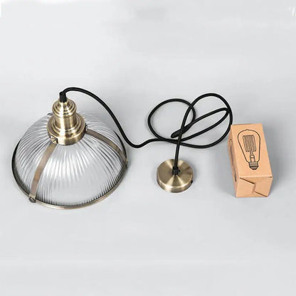 Industrial brushed nickel pendant light with clear ribbed glass shade and brass accents for dining room use