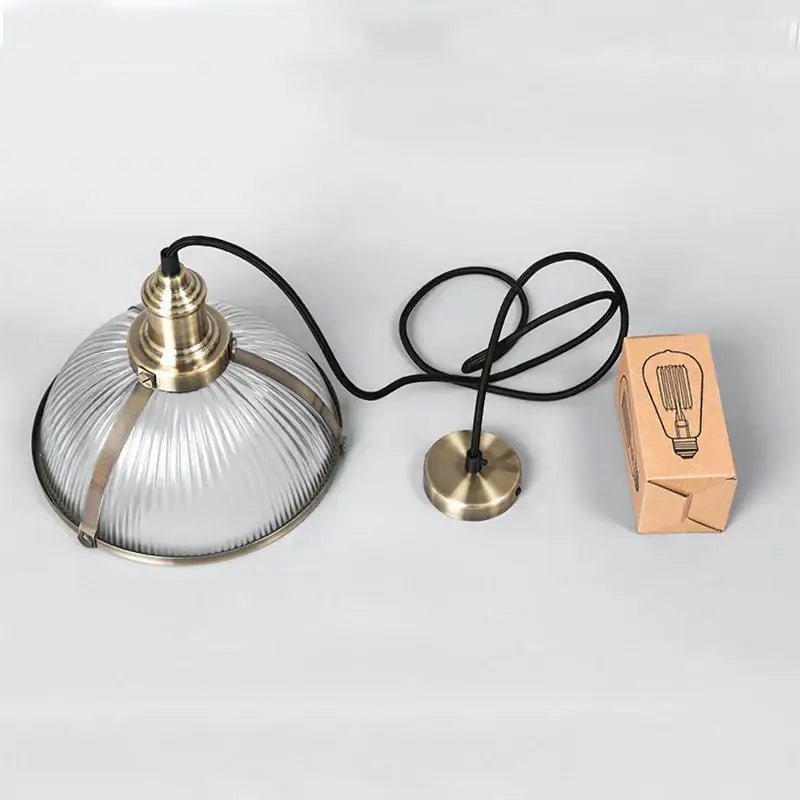 Industrial brushed nickel pendant light with clear ribbed glass shade and brass accents for dining room use