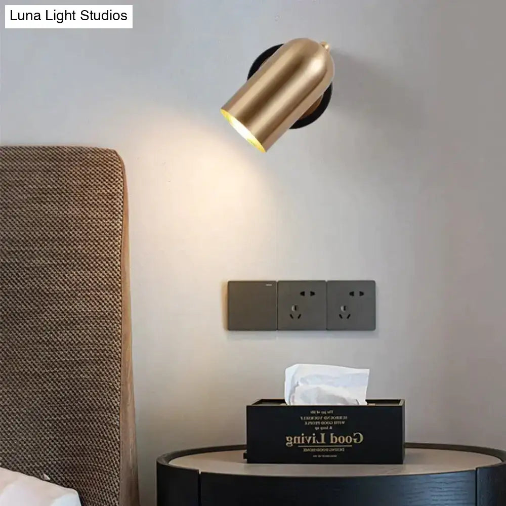 Brass-finished cylindrical industrial led wall sconce with a sleek modern design for bedroom spotlighting