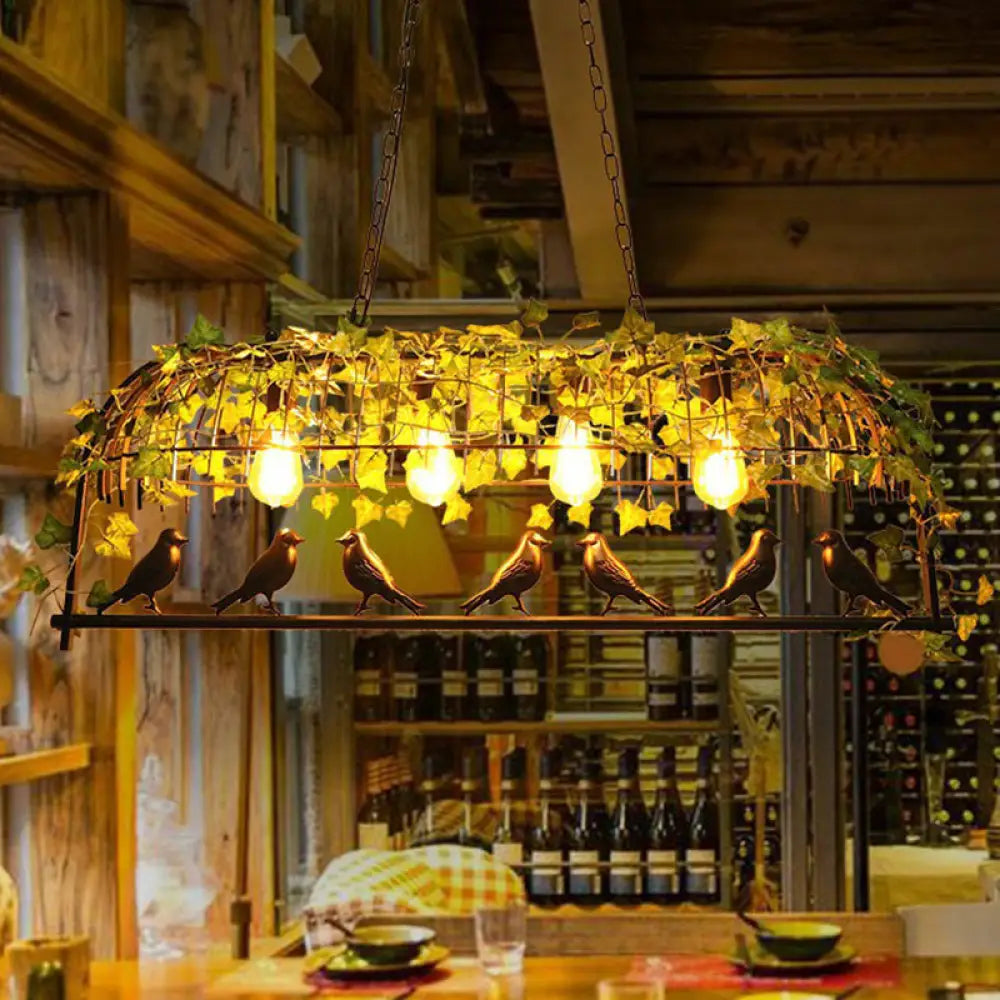 مصباح معلق معدني على شكل قفص صناعي من DecorBites™ مع أوراق خضراء مقلدة لغرفة الطعام