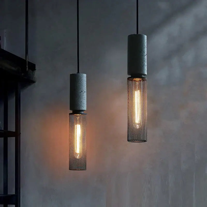 Industrial cement metal pendant light with concrete tops and mesh cages featuring glowing filament bulbs for dining room decorbites industrial cement style