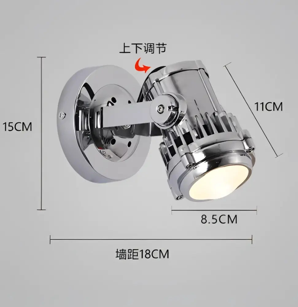 Chrome finished industrial wall lamp with adjustable spotlight head and visible cooling fins for bedroom lighting