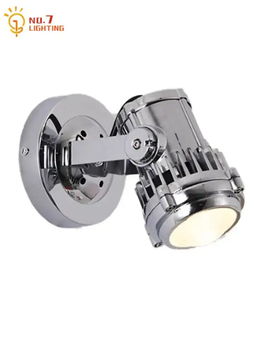 Industrial chrome adjustable wall lamp with vintage style spotlight head and visible cooling fins for bedroom use