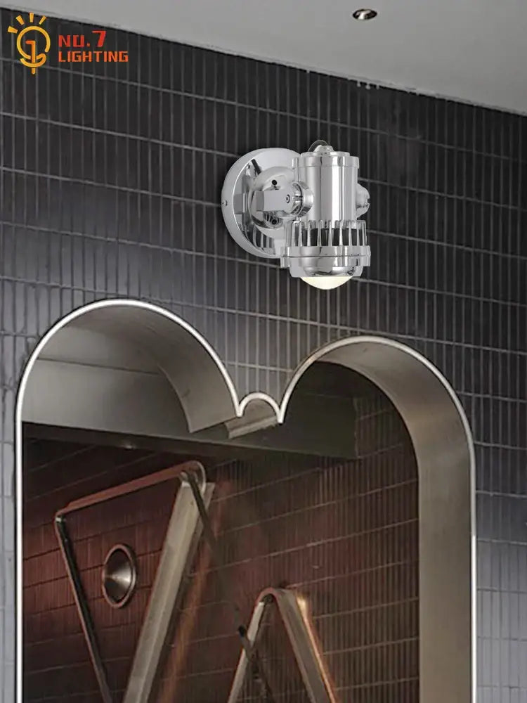 Industrial chrome adjustable wall lamp with cylindrical body and protective mesh grille designed as an industrial wall lamp