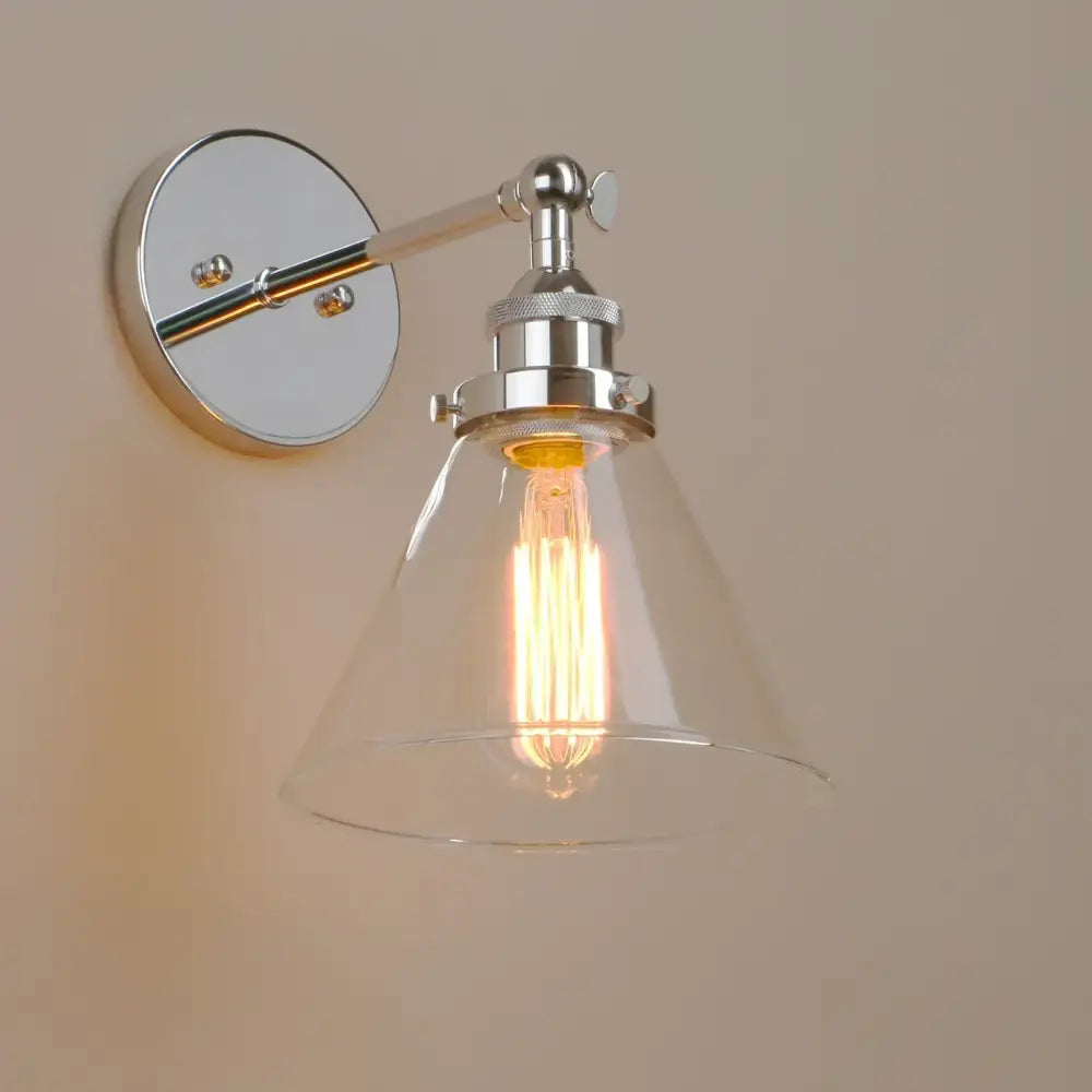 A sleek industrial chrome wall sconce with a clear glass shade and exposed Edison bulb bedroom light fixture