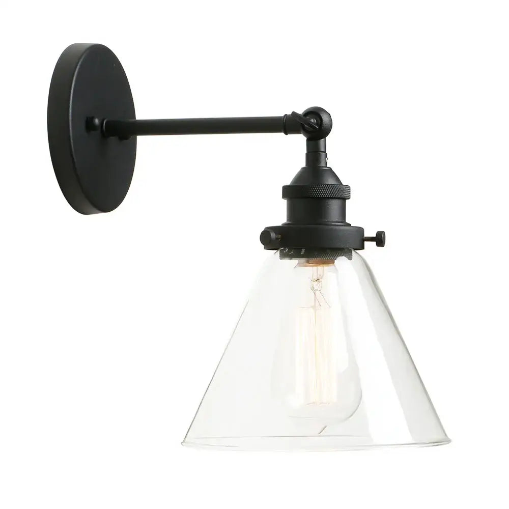Black wrought iron wall sconce with clear glass shade and exposed Edison bulb for industrial bedroom light fixture