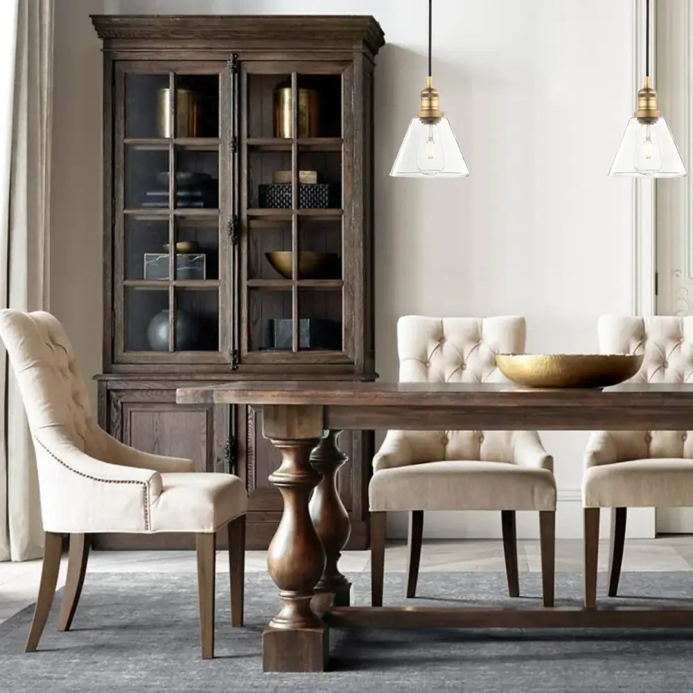 Dark wood dining table with turned legs and central pedestal base featuring industrial clear glass funnel flared pendant light decorbites