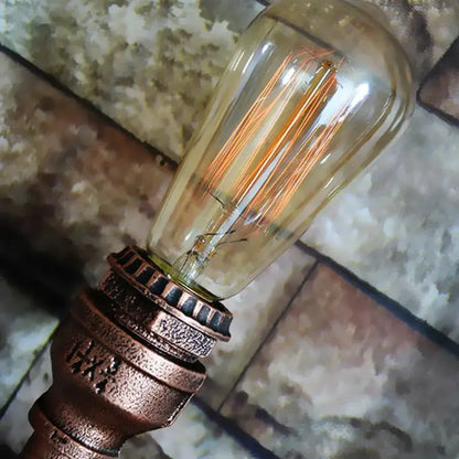 Vintage-style edison bulb with copper filament in amber glass on ornate bronze base industrial iron pipe wall sconce decorbites