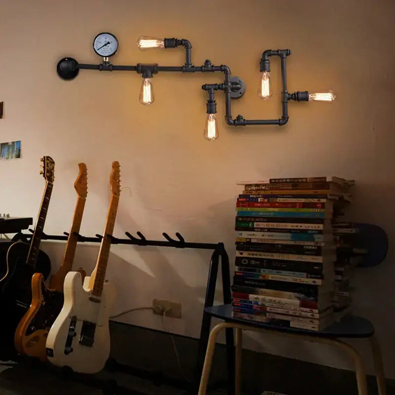 Industrial dark brass pipe wall lights with black exposed filament bulbs and pressure gauge for living room use