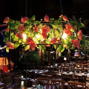 DecorBites™ industrial metal black island pendant light with rectangular frame, artificial pink roses, and warm glowing bulbs