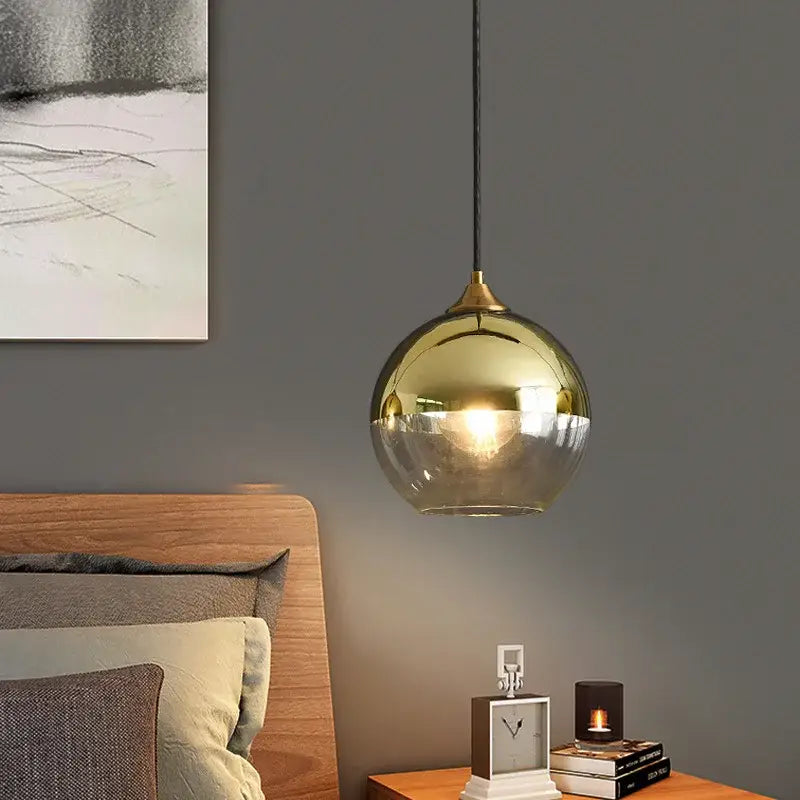 Gold-toned spherical industrial glass pendant light with reflective globe and black cord for kitchen or dining decorbites industrial glass pendant