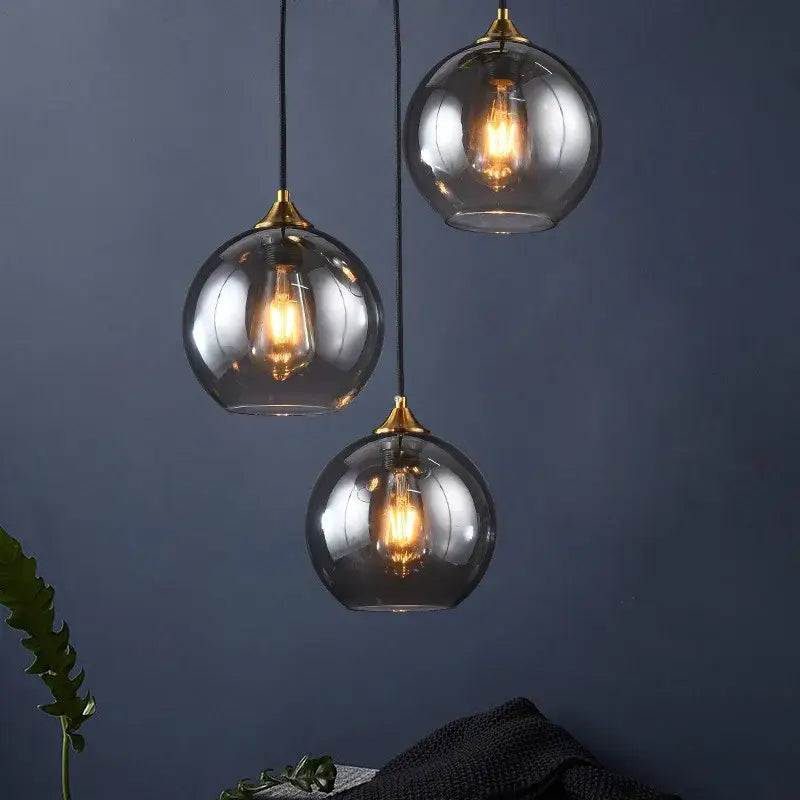 Three spherical glass pendant lights with brass accents and warm filament bulbs for kitchen dining room decorbites industrial glass pendant