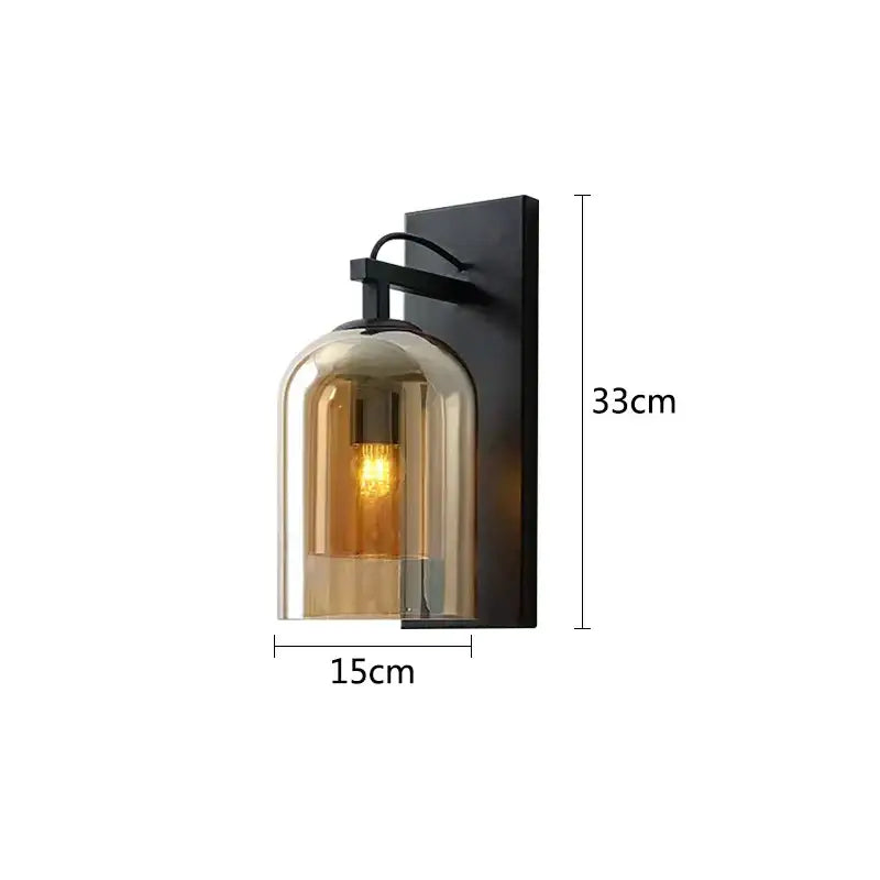 A sleek black metal wall lamp with a warm amber glass dome and exposed filament bulb for industrial glass wall decorbites
