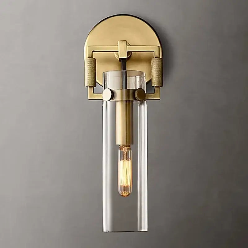 Brass-finished wall lamp with clear glass cylinder and exposed filament bulb decorbites industrial glass wall sconce