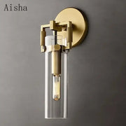 Gold-toned industrial glass wall lamp decorbites with clear cylindrical shade and exposed filament bulb for bedroom sconce