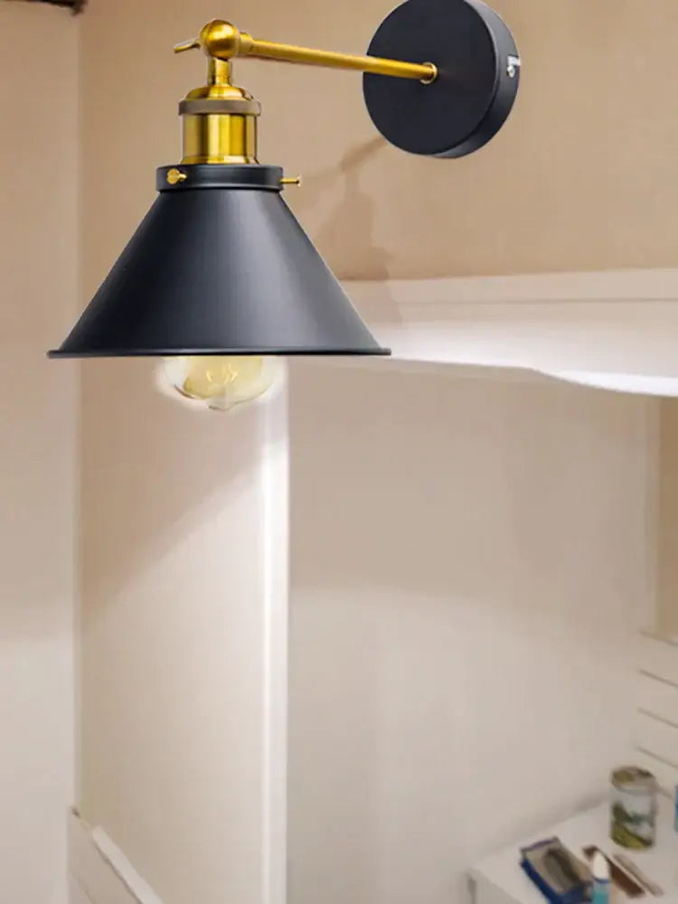 Industrial gold wall lamp with a black metal sconce, brass-finished adjustable arm, and exposed edison bulb decorbites industrial gold