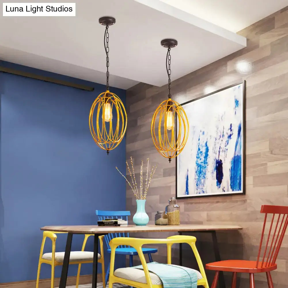 Two golden oval cage pendant lights with exposed bulbs hanging from black chains for industrial decor