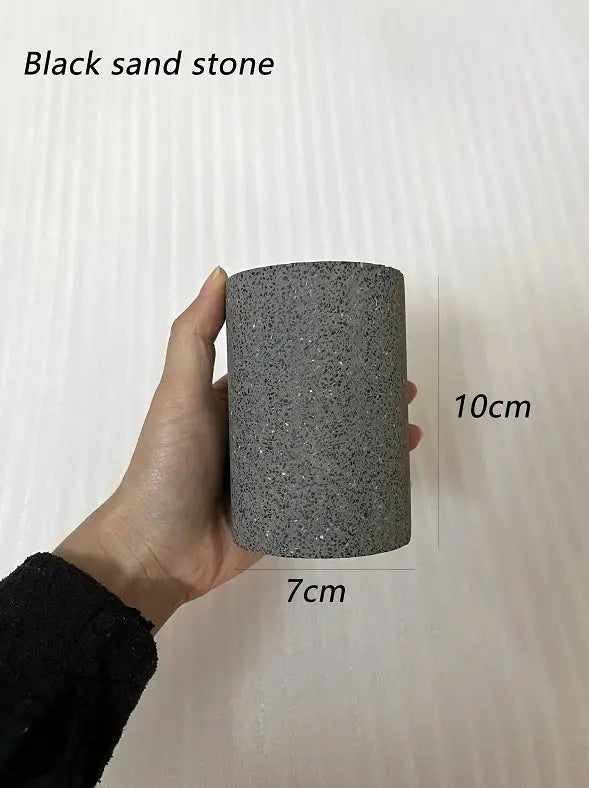 A cylindrical black sandstone planter with a textured surface in a decorbites industrial led gray white concrete ceiling light set