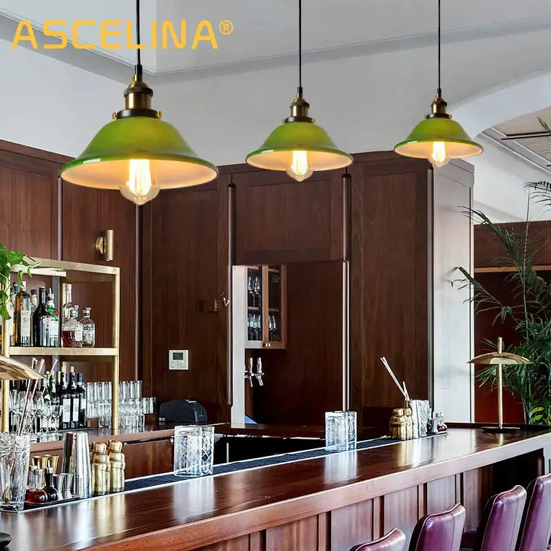 Three vintage-style green glass pendant lights with brass fixtures hang above a wooden bar in a dining room setting