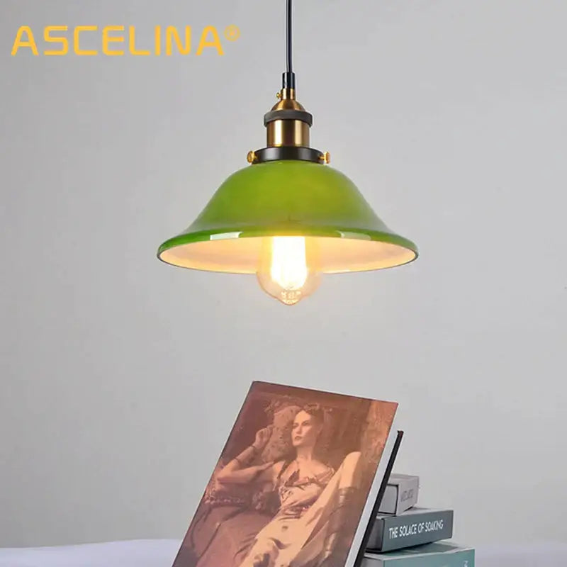 Industrial green glass pendant light with brass accents and visible filament bulb for dining room lighting