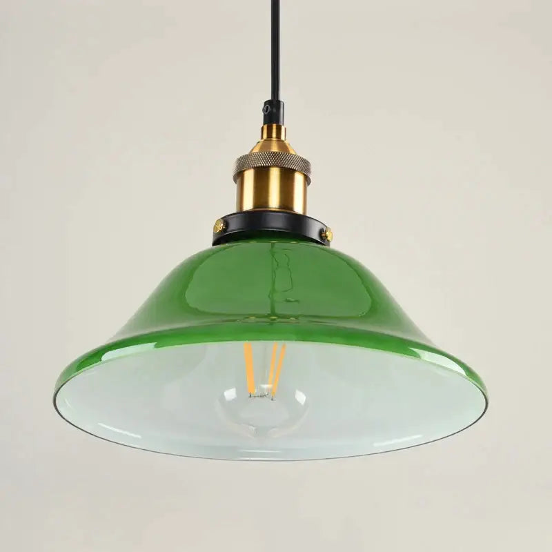Industrial green glass pendant light with brass and black metal accents for dining room use