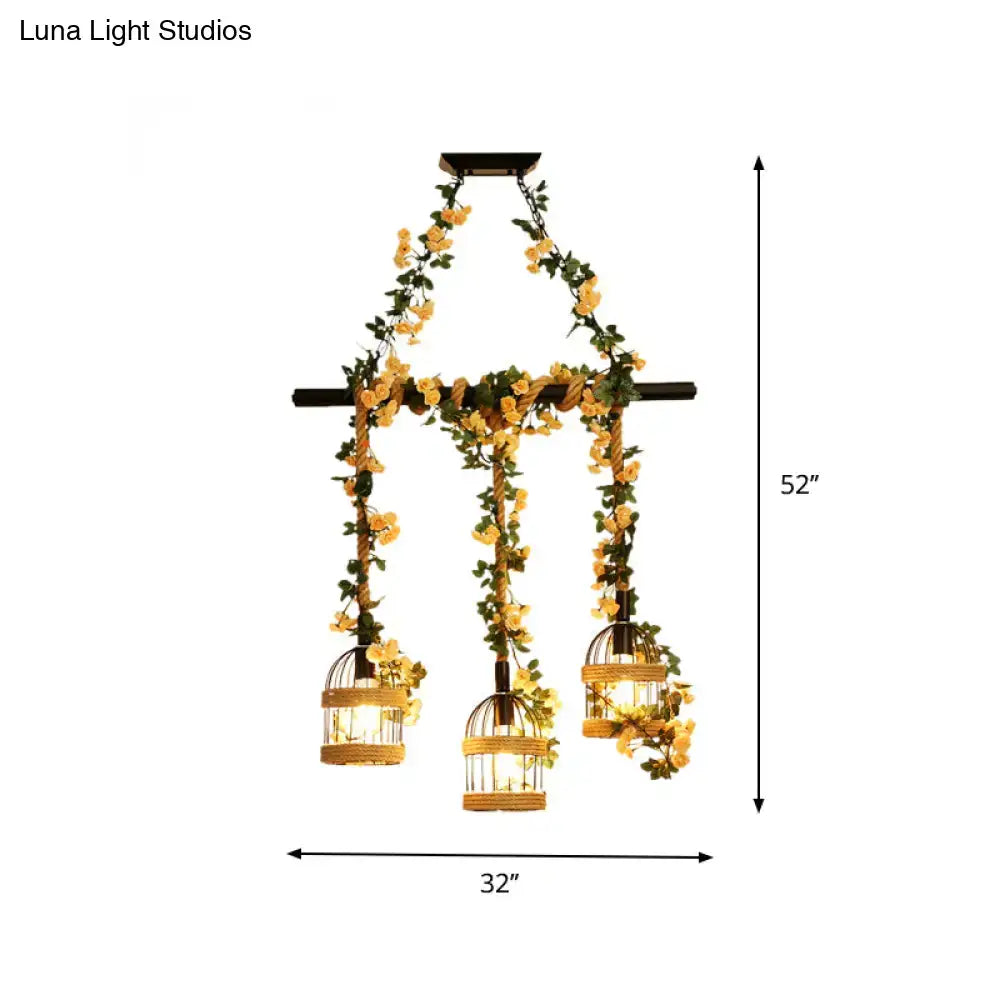 A rustic-style black hanging chandelier with three woven wicker birdcages adorned with yellow flowers using industrial hemp rope for restaurant island lighting