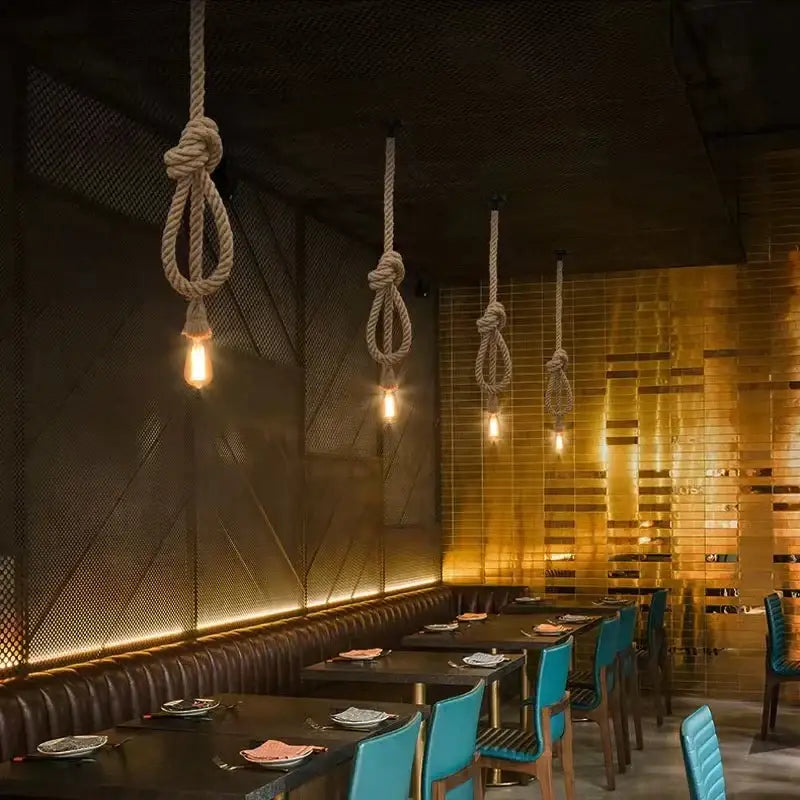 Coiled hemp rope pendant lights with exposed filament bulbs hang from the ceiling in industrial kitchen decorbites hemp rope style