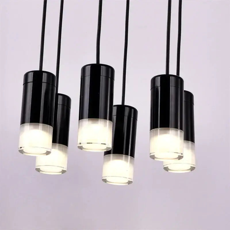 Black cylindrical pendant light with frosted glass base emitting soft white glow decorbites industrial iron art design