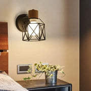 Industrial iron cage wall light with black metal geometric cage wooden top cap and exposed bulb decorbites iron cage