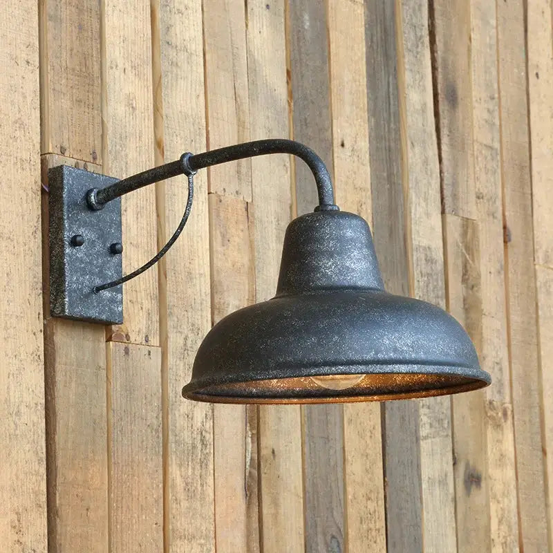 Industrial iron outdoor garden wall lamp featuring a black wrought iron wall lamp with distressed finish and curved arm