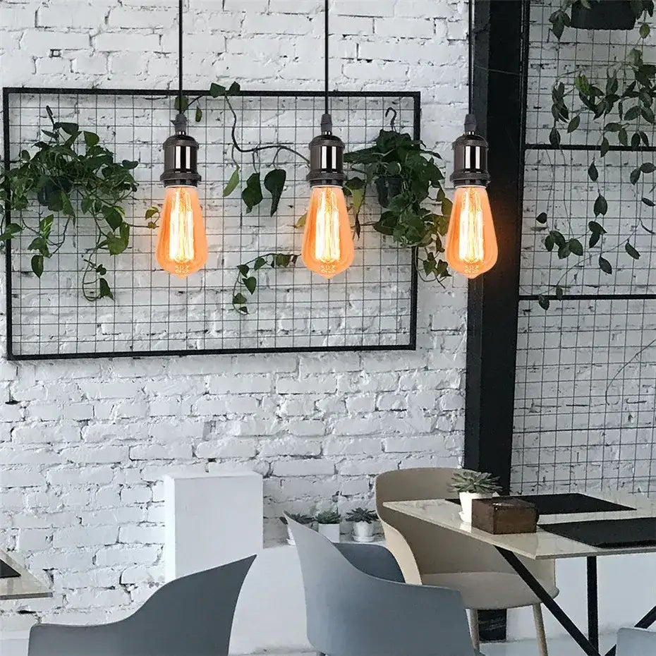 Three hanging edison-style bulbs with warm glow in decorbites industrial loft led black and brass pendant light