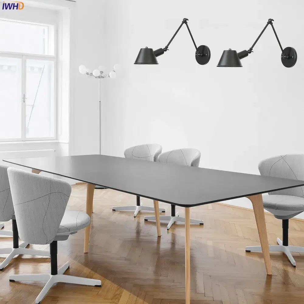 Industrial matte black led wall light fixture above long gray conference table with light wood legs in bedroom setting