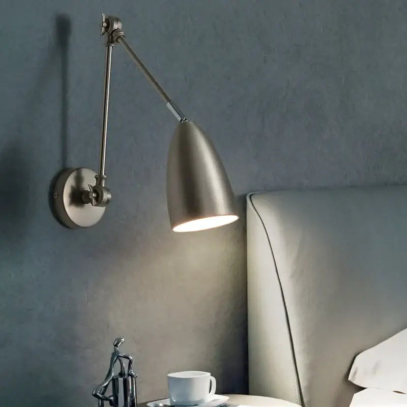A sleek industrial matte black decorbites adjustable swing long arm wall lamp with brushed metallic conical shade