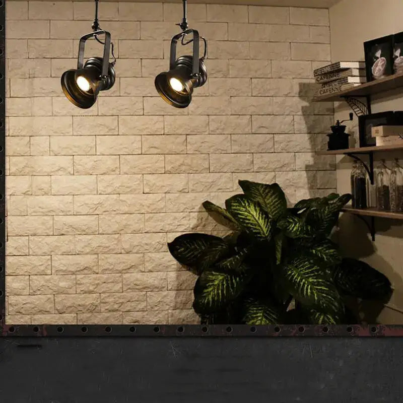 Two vintage-style industrial matte black retro dome pendant lights with brass heads hang in a dining room chandelier setup