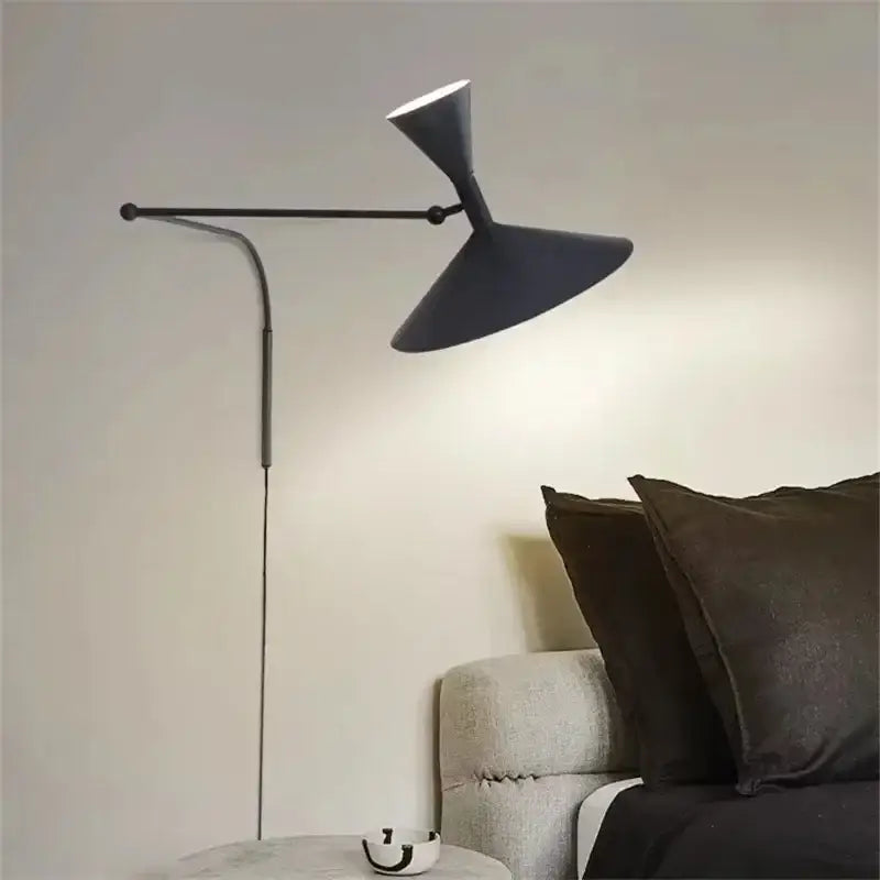 Industrial matte black wall sconce lamp with dual conical shades and a sleek curved arm for bedroom use