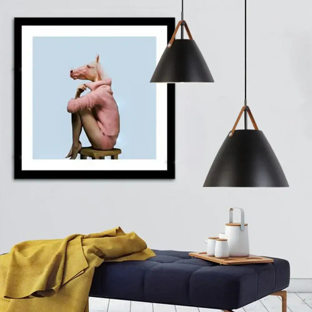Black-framed art print with pink horse in hoodie paired with industrial matte black and wood pendant light fixture kitchen