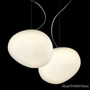 Two off-white industrial pendant lights with oval shapes and curved metallic cords for living room decorbites industrial living
