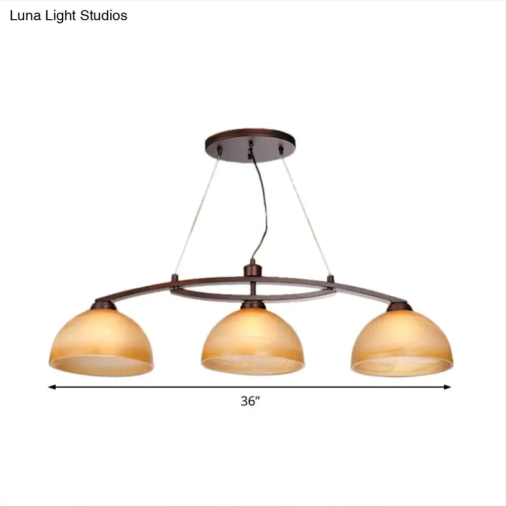 Bronze finished three-light pendant fixture with warm amber glass shades in oil rubbed bronze for indoor use