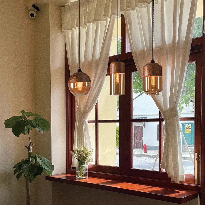 Three warm-toned glass led pendant lights with wooden accents ideal as a light source for dining room decor