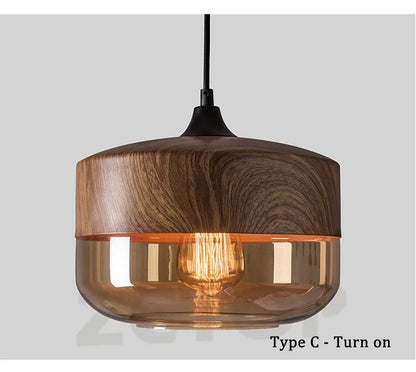 Warm-toned amber glass led pendant light with dark wood top and black cord for dining room light source