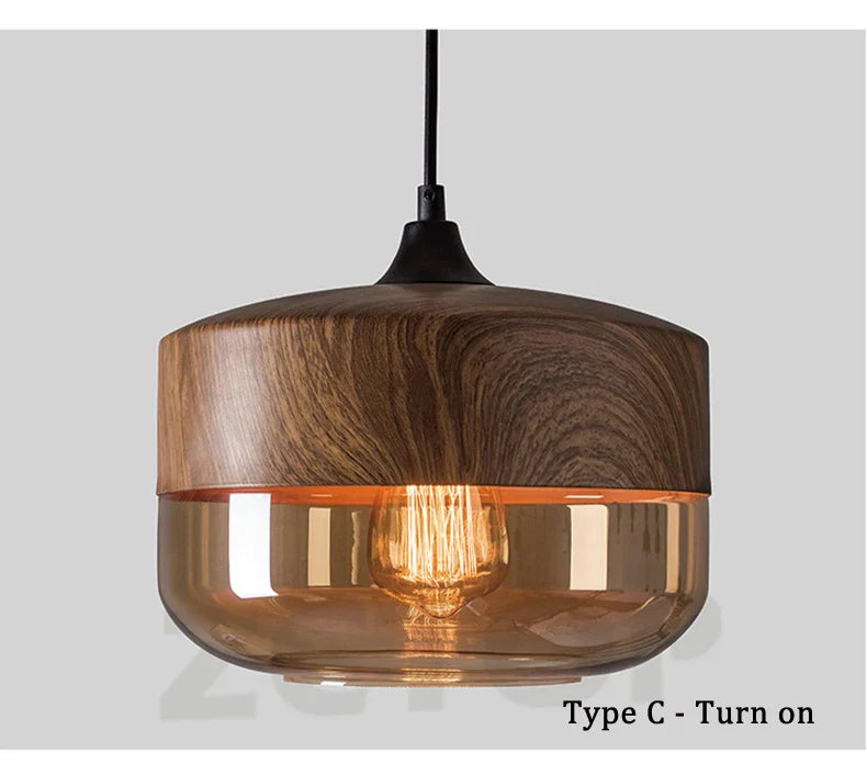Warm-toned amber glass led pendant light with dark wood top and black cord for dining room light source
