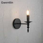 Black wrought iron industrial retro wall sconce with candle-style lit bulb for bedroom decorbites decorbites industrial retro
