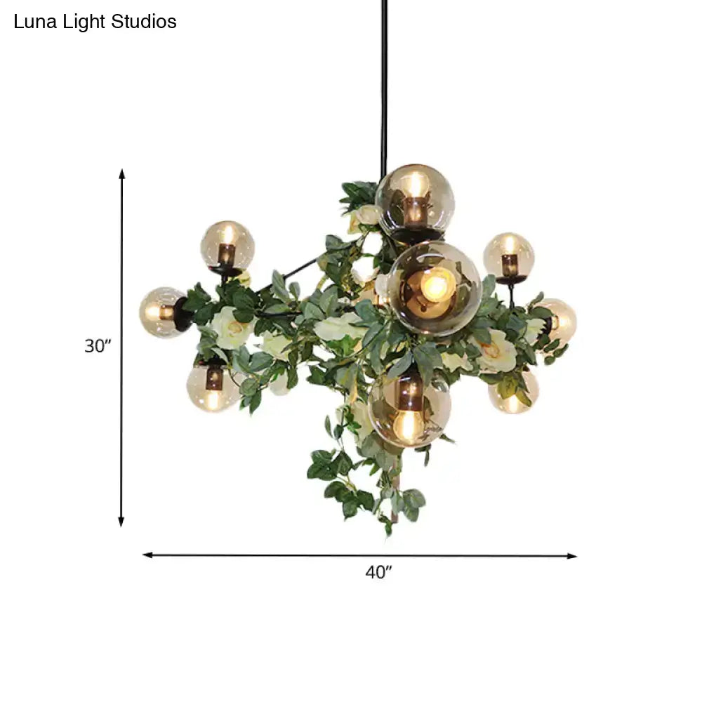 Decorbites industrial globe island pendant featuring smoke gray glass globes with black geometric cage and green vine accents