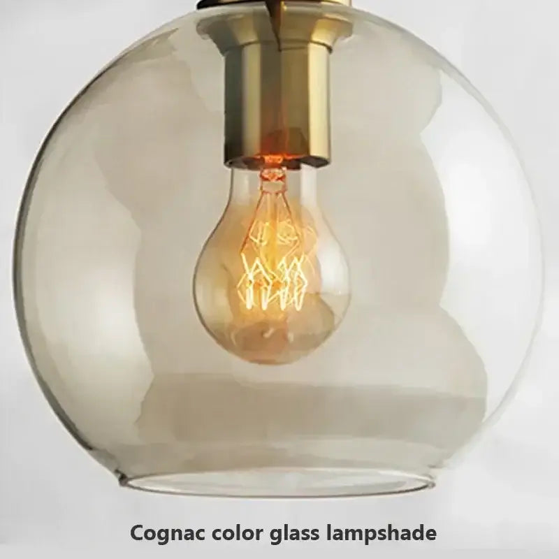 Cognac-colored industrial glass pendant light with brass fixture and exposed filament bulb for dining room decorbites industrial glass