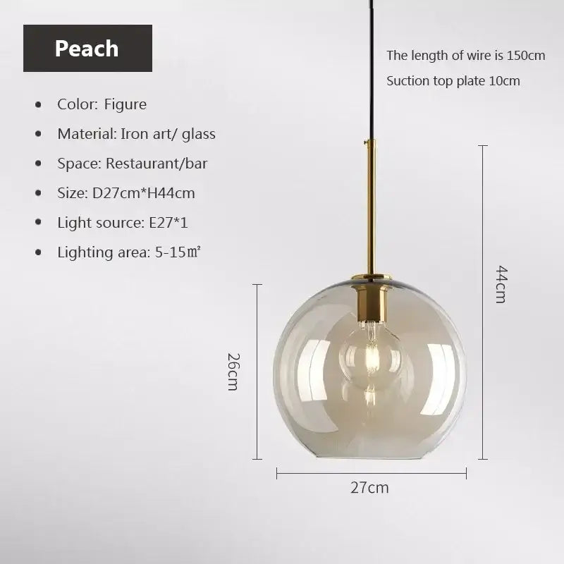 Peach-colored spherical pendant light with clear glass globe and brass hardware for dining room decorbites industrial glass design
