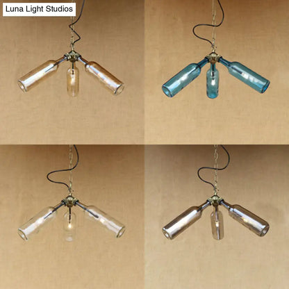 Lámpara de araña de estilo industrial con tres luces, hecha con botellas de vidrio y diseño de tuberías, en negro y transparente.