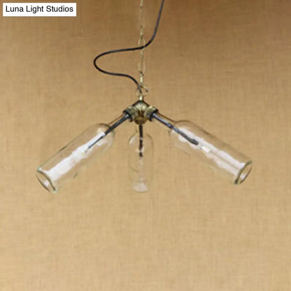 Lámpara de araña de estilo industrial con tres luces, hecha con botellas de vidrio y diseño de tuberías, en negro y transparente.