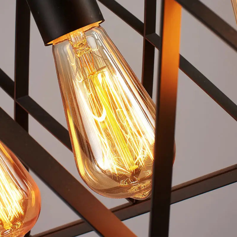 Warm-toned clear glass edison bulb with visible filament in industrial style black ironwork rectangular island light for kitchen